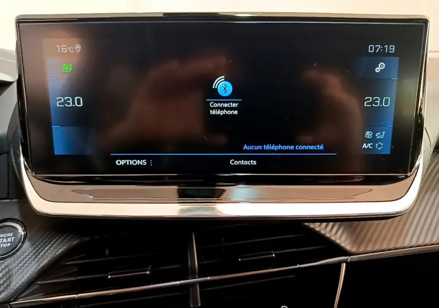Écran tactile central du tableau de bord de la Peugeot 2008 gris clair, affichant la connexion Bluetooth et la climatisation à 23°C.