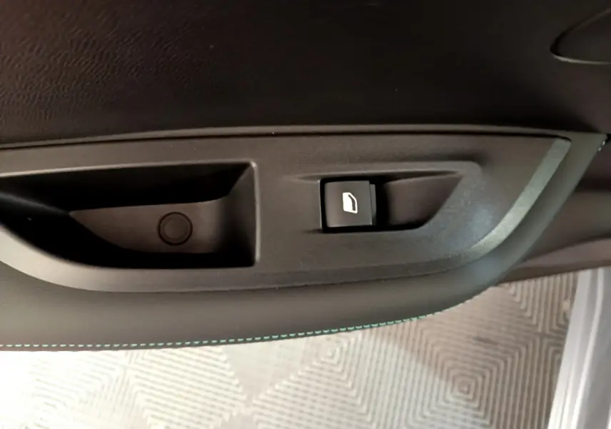 Bouton de commande de vitre électrique sur la porte intérieure côté conducteur d'un Peugeot 2008 gris clair 2021.