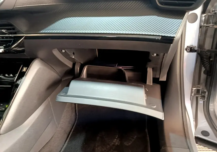 Boîte à gants ouverte côté passager dans l’habitacle gris clair du Peugeot 2008 PureTech 130 2021