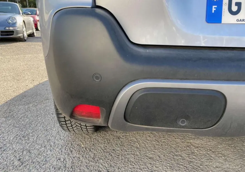 Gros plan sur le coin arrière gauche du Citroën C3 Aircross gris foncé 2024, avec feu rouge et pare-chocs noir.