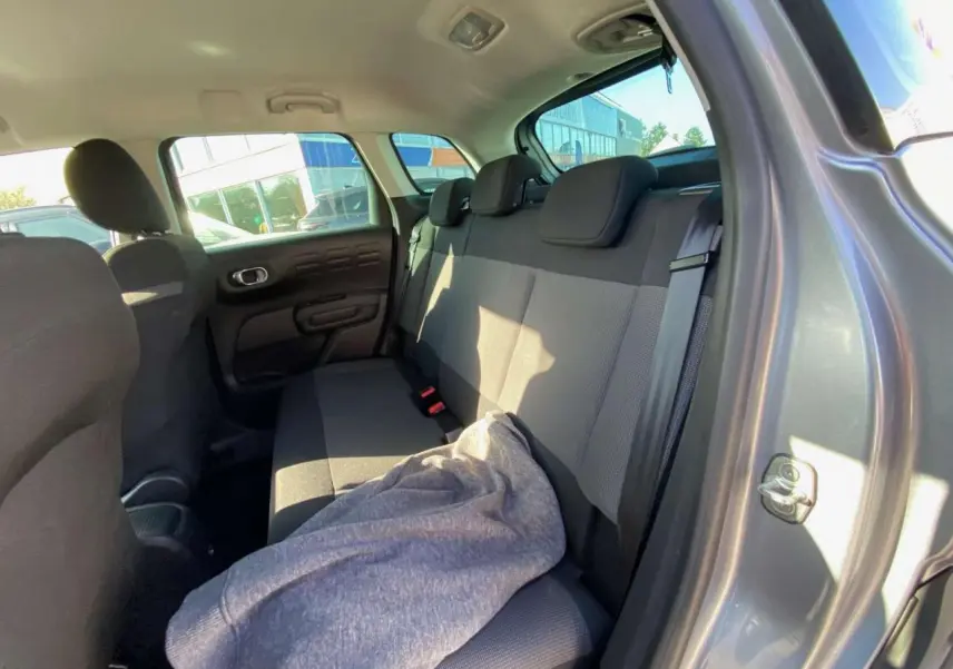 Vue intérieure arrière côté droit du Citroën C3 Aircross gris foncé 2024, montrant la banquette arrière et la portière ouverte.