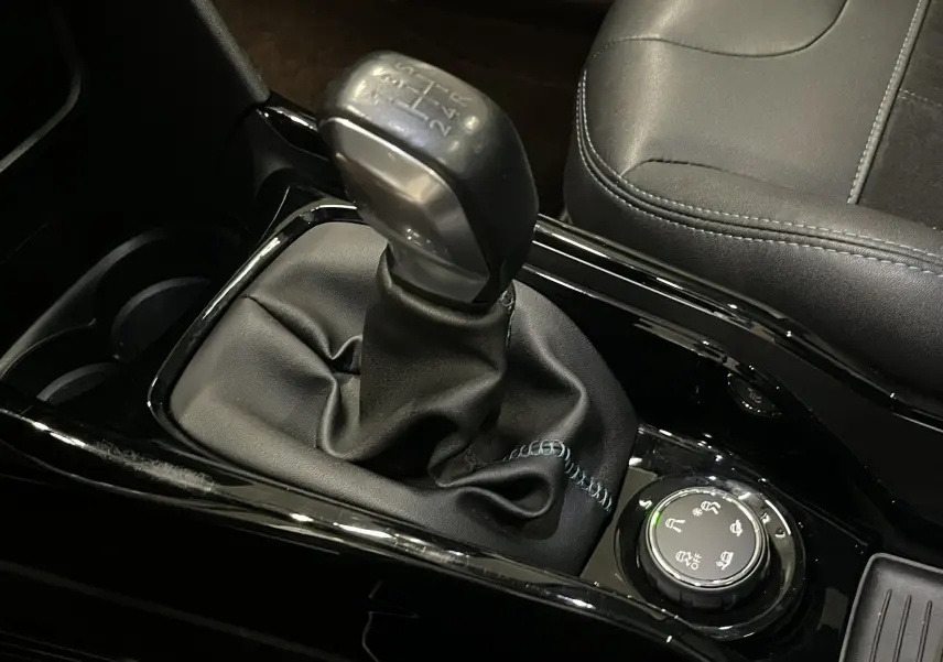 Gros plan sur le levier de vitesses manuel et la molette de sélection de mode de conduite, intérieur noir du Peugeot 2008.