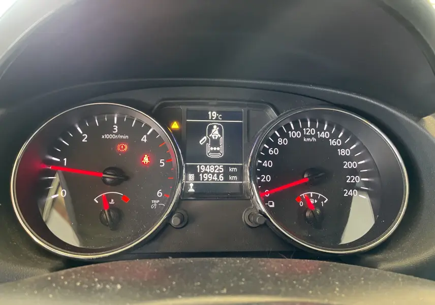 Tableau de bord du Nissan Qashqai blanc 2013, affichant compte-tours, vitesse, température et kilométrage.