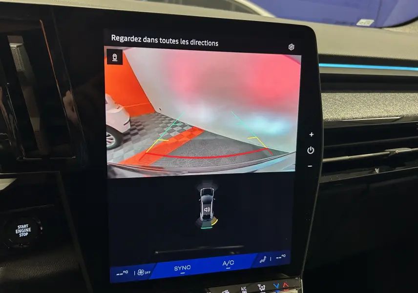 Écran central du Renault Austral Ph.2 E-TECH affichant la caméra de recul avec lignes de guidage colorées dans un parking.
