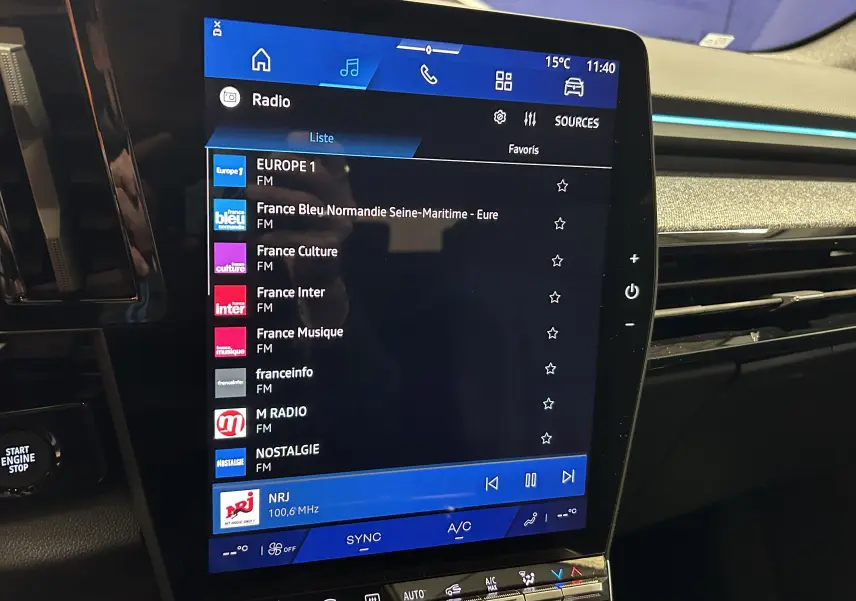 Écran tactile central du Renault Austral Ph.2 E-TECH noir étoilé, affichant la liste des radios FM avec interface moderne.