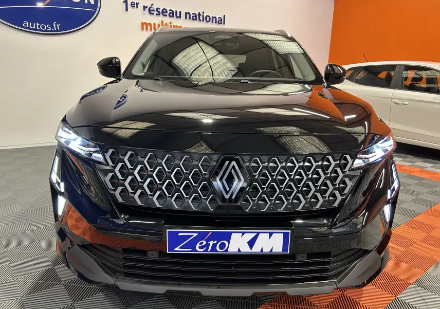 Renault Austral Ph.2 E-TECH noir étoilé, vue frontale mettant en valeur la calandre hexagonale et les phares LED allumés.