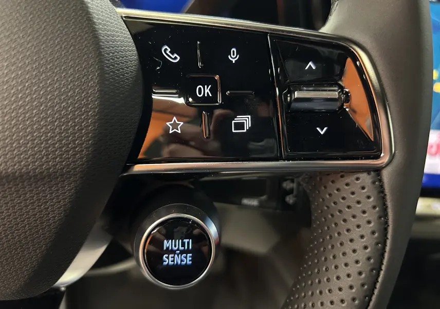 Gros plan sur les commandes multifonctions à droite du volant perforé du Renault Austral noir étoilé 2025.