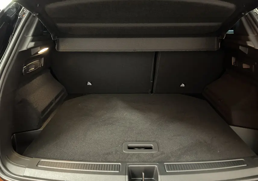 Coffre ouvert du Renault Austral Ph.2 E-TECH noir étoilé, vue intérieure arrière avec hayon électrique relevé.