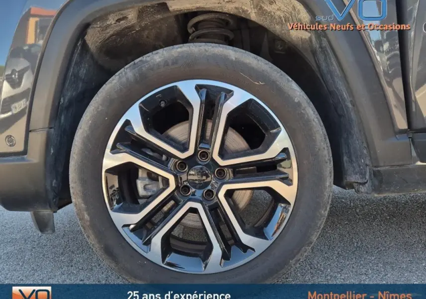 Gros plan sur la jante alliage 18 pouces noire et argent du Jeep Compass gris 2024 côté arrière droit.