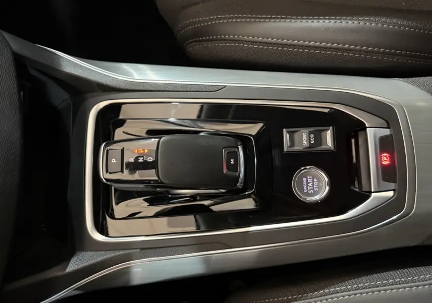 Vue rapprochée de la console centrale de la Peugeot 308 noire, avec levier de boîte auto, bouton start/stop et sélecteur mode sport/eco.