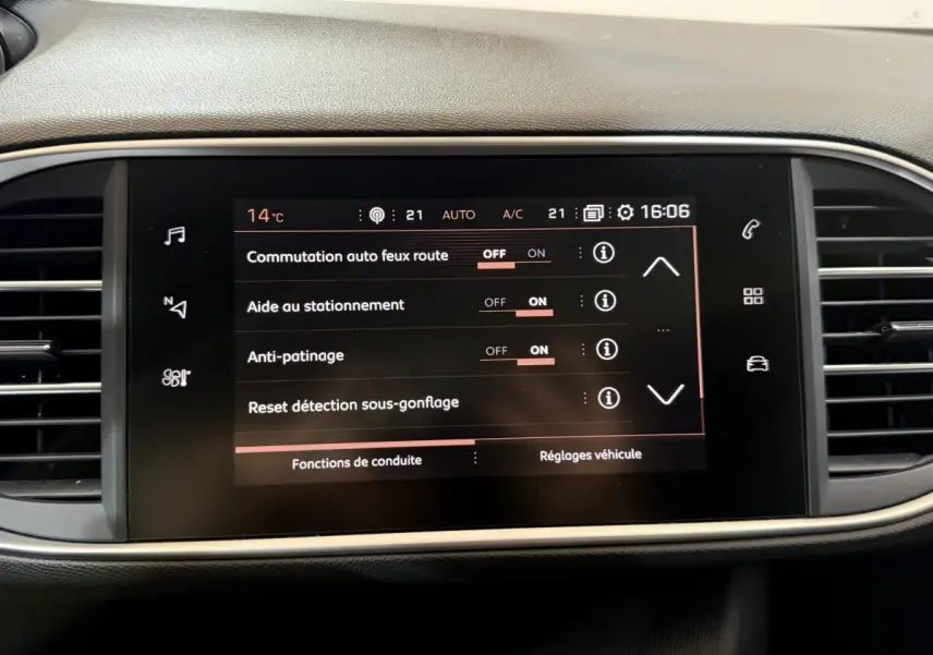 Écran tactile central affichant les réglages d'aide à la conduite dans l'habitacle d'une Peugeot 308 noire de 2020.