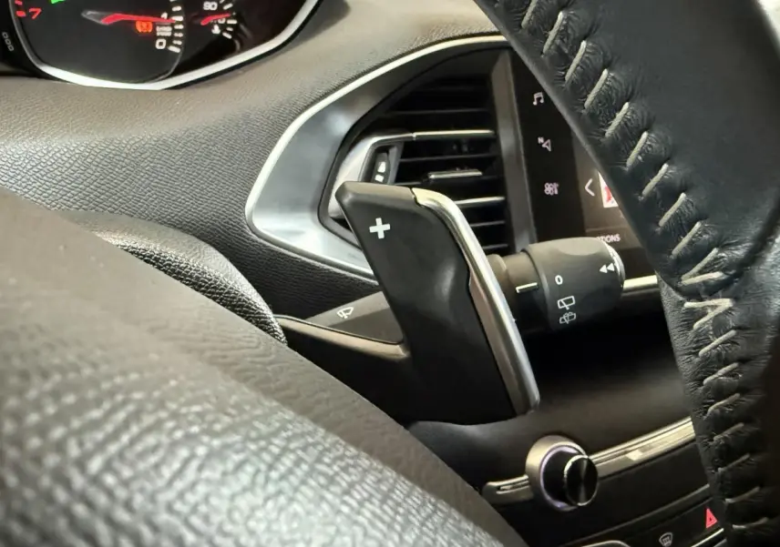 Gros plan sur la palette de changement de vitesse côté gauche du volant cuir noir d'une Peugeot 308 Puretech 130 Allure 2020.