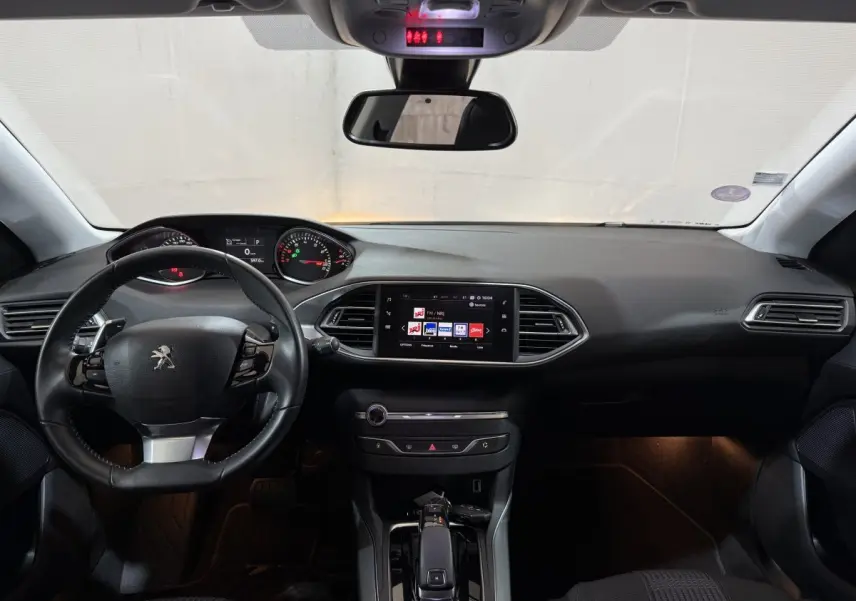 Intérieur noir de la Peugeot 308 2020, vue frontale du tableau de bord avec écran tactile et volant multifonctions cuir.