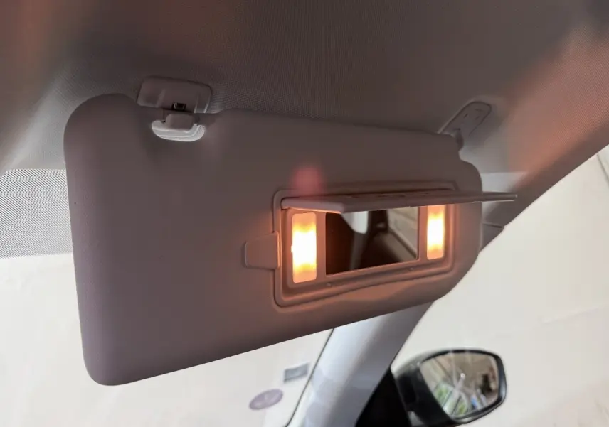 Miroir de courtoisie éclairé sur pare-soleil côté gauche dans l'habitacle d'une Peugeot 308 noire de 2020.