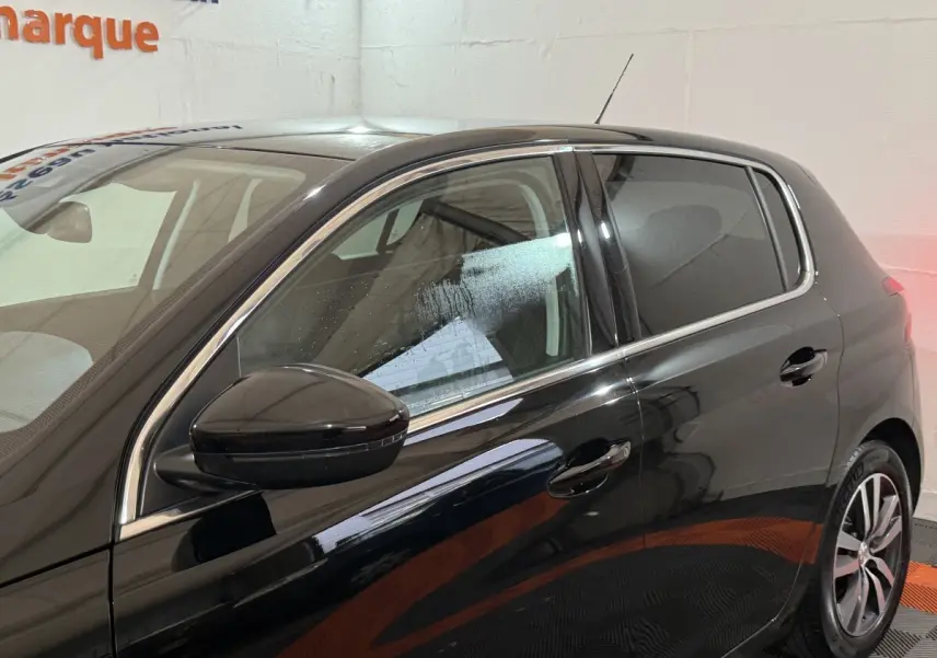 Vue latérale gauche d'une Peugeot 308 noire de 2020, mettant en valeur la finition brillante et les jantes alliage.