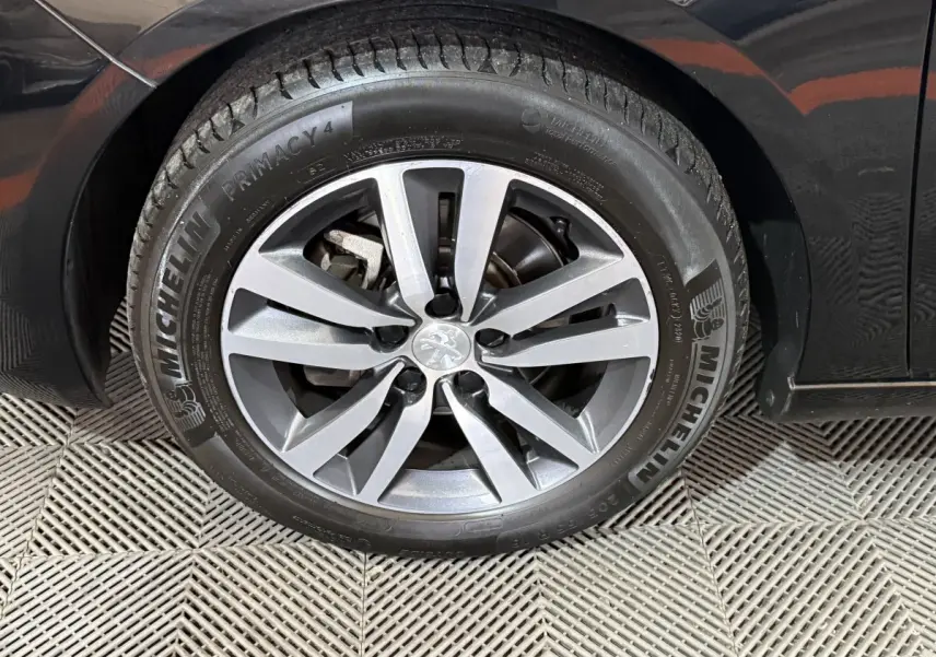 Gros plan sur la roue avant droite noire d'une Peugeot 308 2020 avec jante alliage et pneu Michelin.