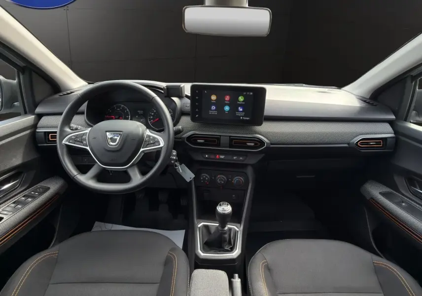Vue intérieure avant de la Dacia Sandero Stepway Expression ECO-G 100 2022, tableau de bord noir avec écran tactile central.