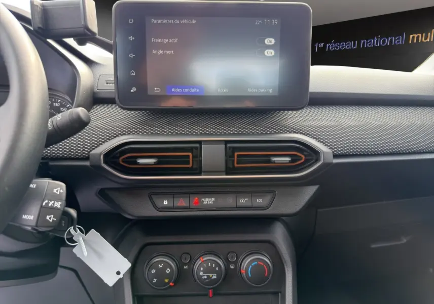 Vue intérieure centrée sur le tableau de bord de la Dacia Sandero Stepway 2022 avec écran tactile et commandes climatisation.