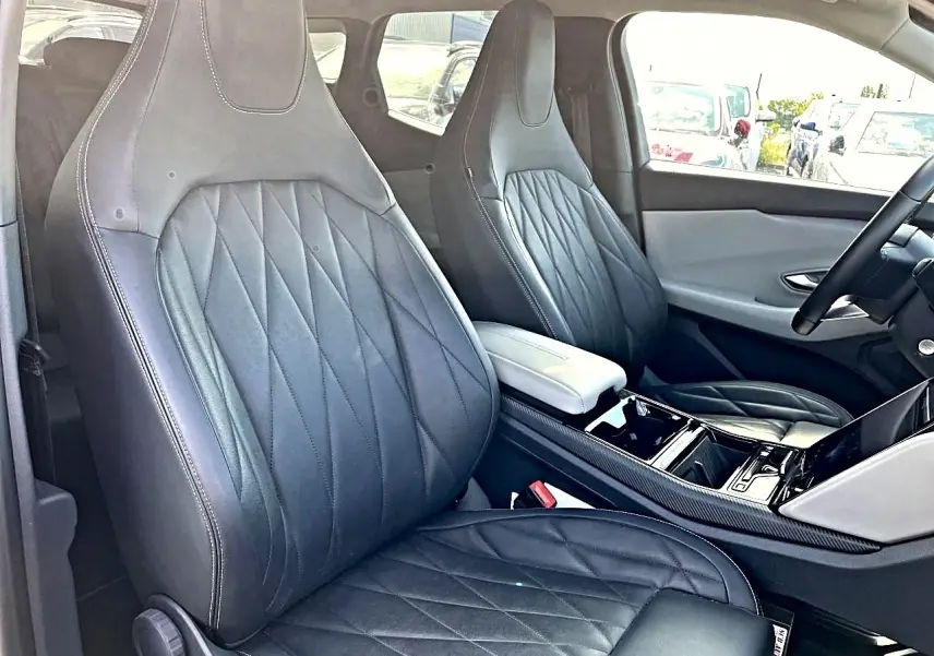 Vue intérieure côté avant droit du Ford Explorer 2025 gris, mettant en valeur les sièges en cuir noir et la console centrale.