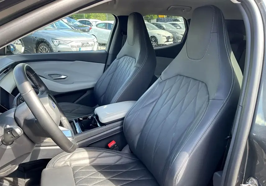 Vue intérieure côté conducteur du Ford Explorer gris 2025, mettant en valeur les sièges sport en cuir noir et l'accoudoir central.