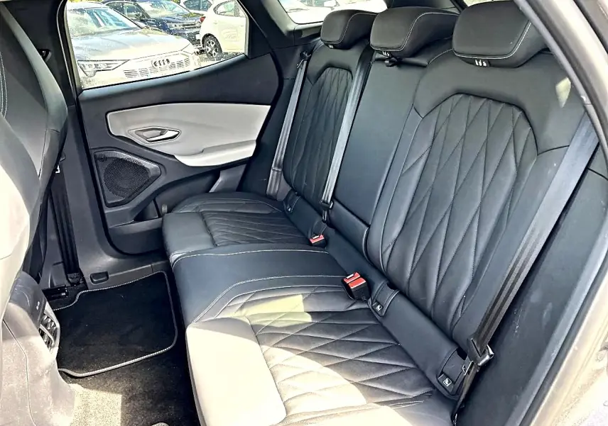 Vue côté droit de la banquette arrière en cuir noir matelassé du Ford Explorer gris, avec ceinture de sécurité et porte bicolore.