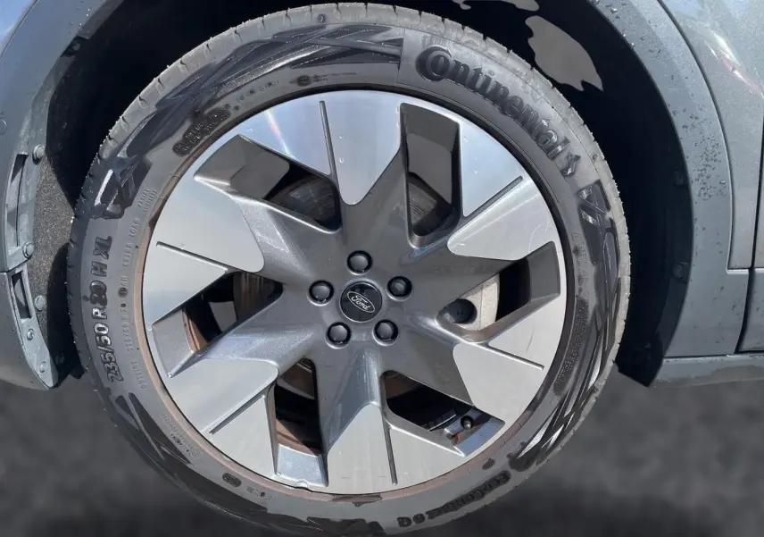 Gros plan sur la jante alu grise et noire du Ford Explorer électrique gris, avec pneu Continental visible.