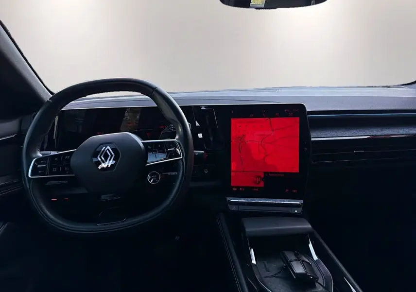 Vue intérieure du tableau de bord noir du Renault Austral 2023 avec volant cuir multifonction et écran tactile central vertical.