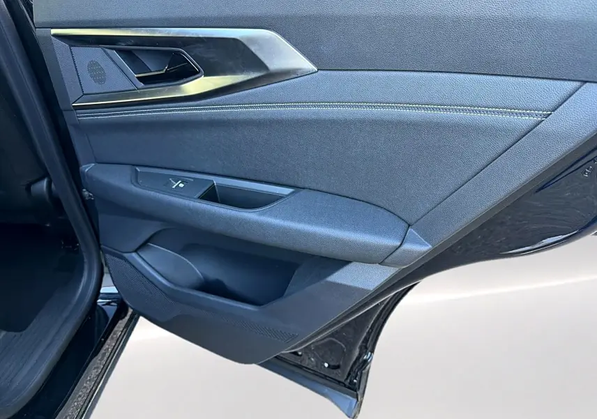 Vue rapprochée de la porte arrière gauche noire du Renault Austral 2023 avec garniture tissu et plastique noir.