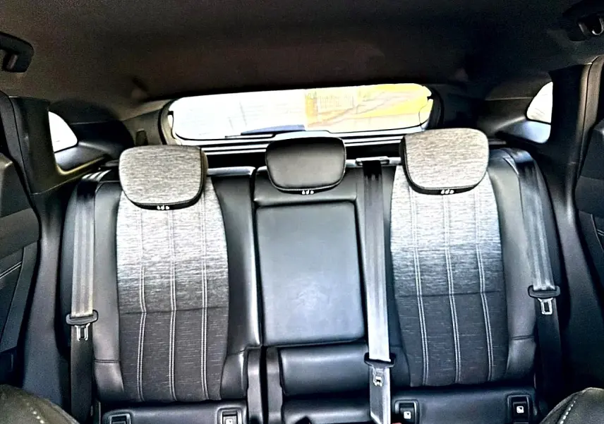 Vue arrière intérieure montrant la banquette arrière gris dégradé avec appuie-têtes et ceintures de sécurité du Renault Austral noir.