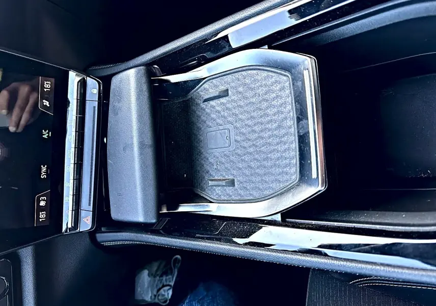 Vue plongeante sur la console centrale noire du Renault Austral 2023 avec accoudoir et espace de rangement fermé.