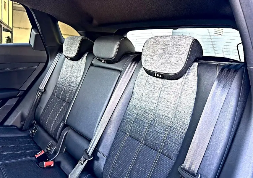 Vue intérieure arrière montrant la banquette gris dégradé avec appuie-têtes et ceintures de sécurité du Renault Austral noir.