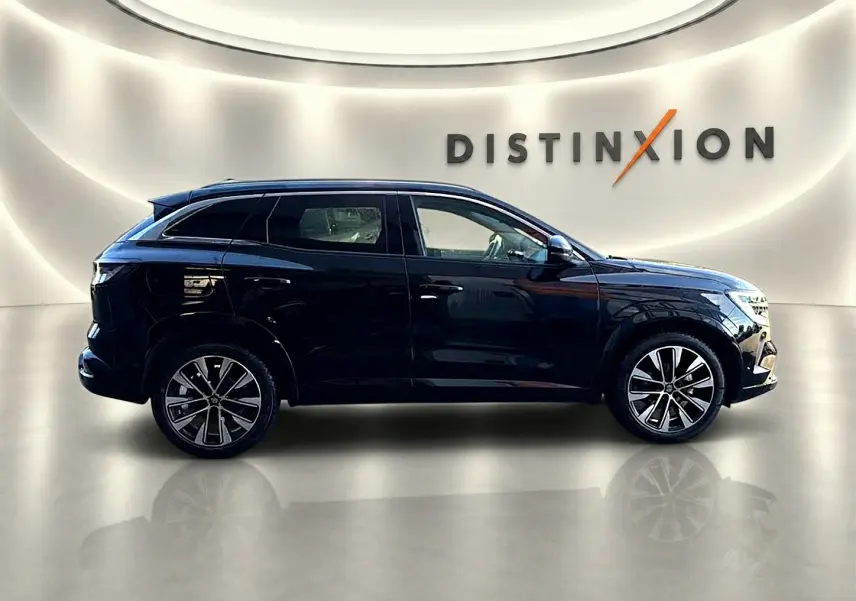 Profil droit d'un Renault Austral noir 2023 avec jantes alu, posé devant un mur blanc éclairé et le logo Distinxion.