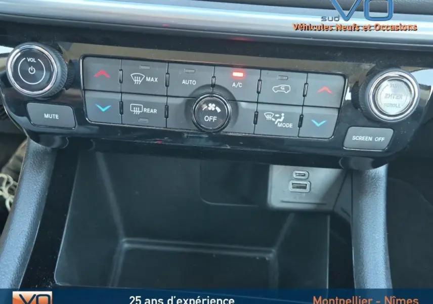 Vue rapprochée de la console centrale du Jeep Compass 2024, montrant les commandes de climatisation et ports USB.