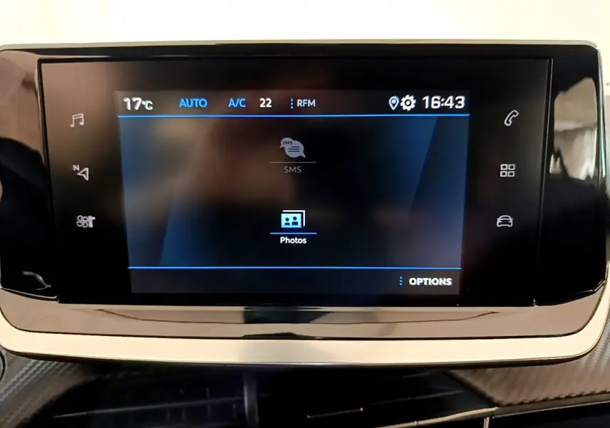 Écran tactile central du tableau de bord du Peugeot 2008 gris foncé, affichant les options multimédia et climatisation.