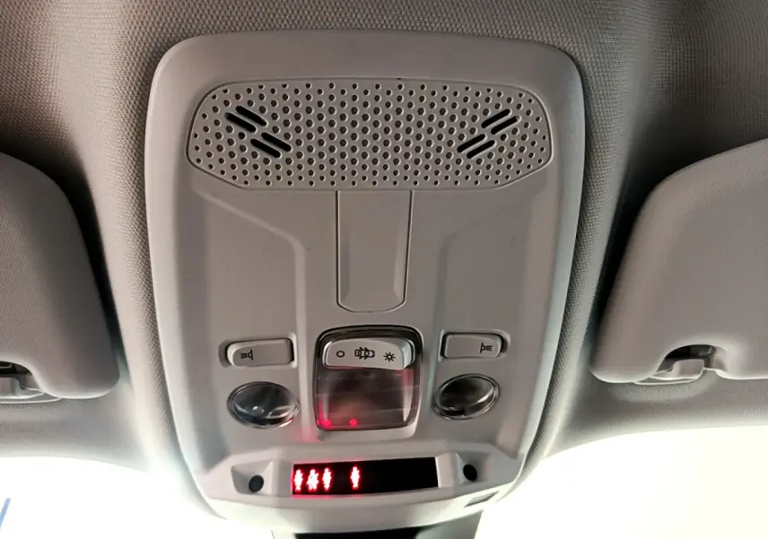 Plafonnier intérieur avec commandes d'éclairage et alertes, Peugeot 2008 gris foncé, vue vers le toit depuis l'habitacle.
