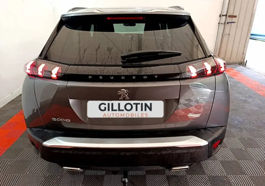 Vue arrière d'un Peugeot 2008 gris foncé avec feux LED caractéristiques et attelage visible.