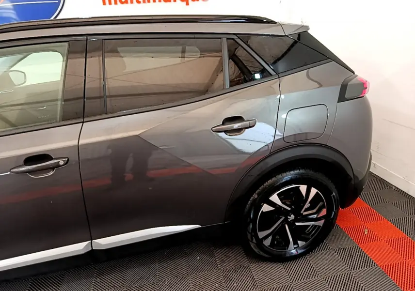Vue côté droit arrière du Peugeot 2008 gris foncé, avec jantes alliage noires et toit noir contrastant.