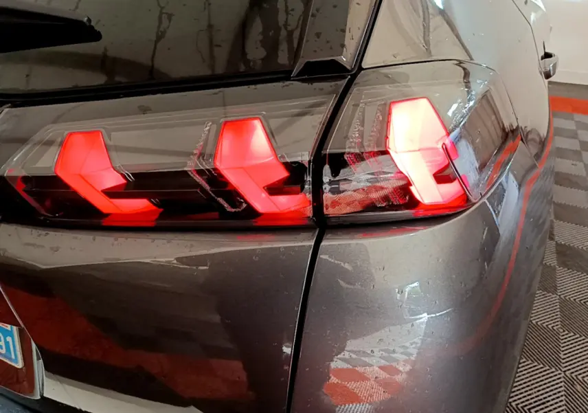 Gros plan sur le feu arrière droit rouge du Peugeot 2008 gris foncé, mettant en valeur son design LED distinctif.