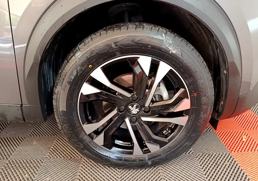 Gros plan sur la roue avant droite gris foncé du Peugeot 2008 avec jante alliage noire et argentée au design moderne.