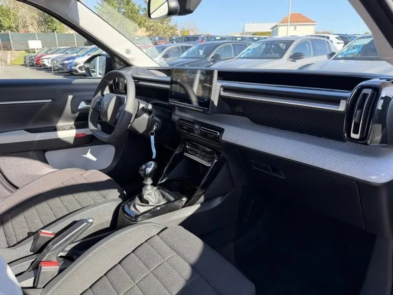 Intérieur de la Citroën C3 2025 en gris Mercury, vue côté conducteur montrant tableau de bord et boîte manuelle.
