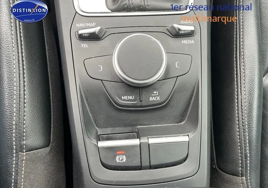 Vue rapprochée de la console centrale noire avec commandes multimédia et frein à main électrique d'Audi Q2.