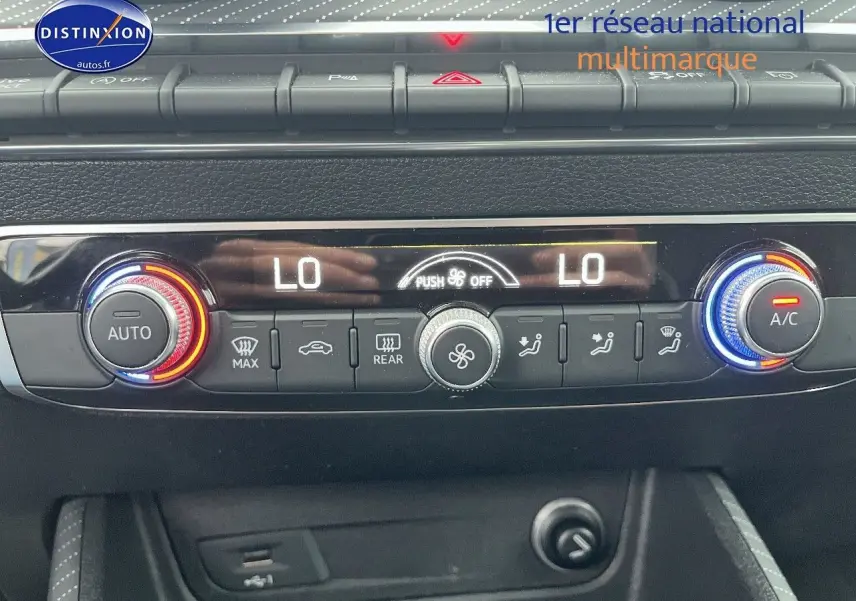 Gros plan sur la console de climatisation automatique de l'Audi Q2 avec réglages température et ventilation affichés.