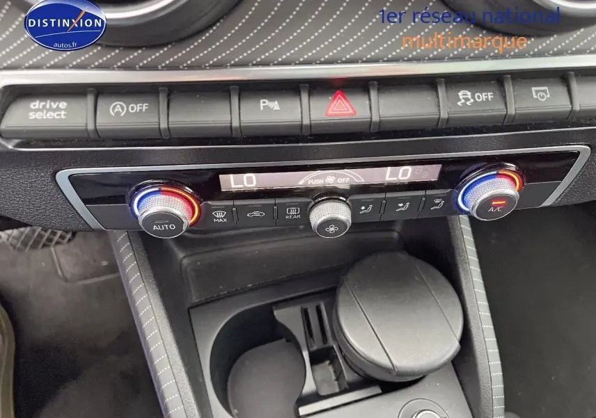 Vue rapprochée du tableau de bord et console centrale de l'Audi Q2 2018 avec commandes climatisation et rangements.