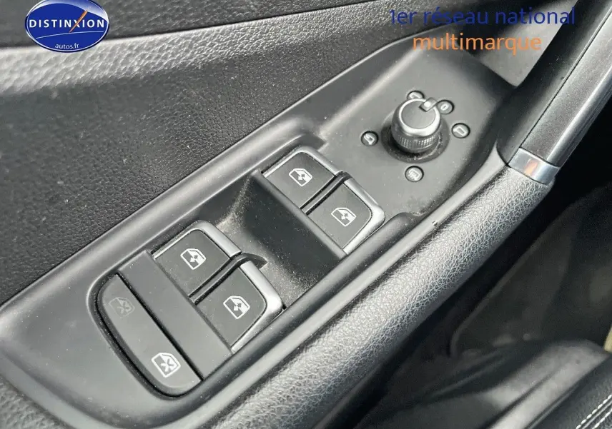 Gros plan sur les commandes de lève-vitres et rétroviseurs côté conducteur d’un Audi Q2 2018 intérieur noir.