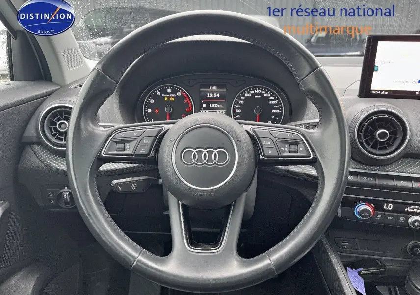 Vue frontale du volant cuir noir multifonction de l'Audi Q2 2018 avec tableau de bord et écran central visibles.
