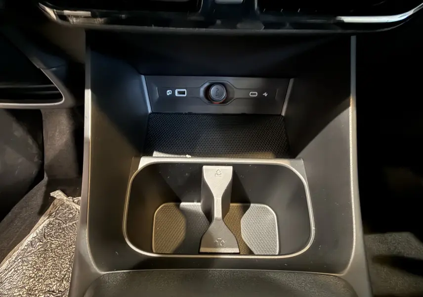 Vue rapprochée de la console centrale noire du MG3 1.5 L Hybrid+ 195 ch Luxury avec porte-gobelets et prise 12V.