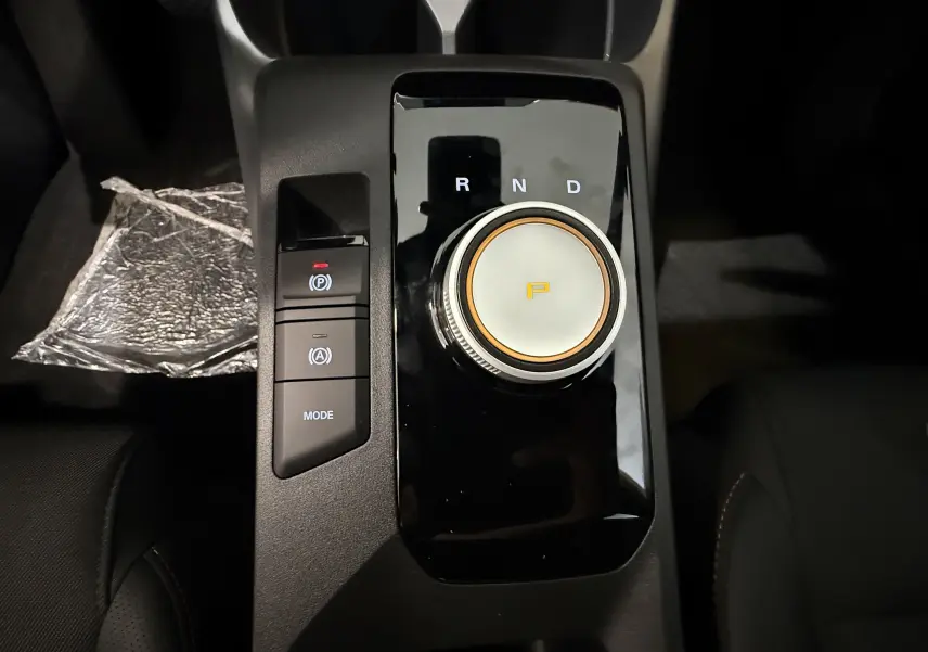 Gros plan sur la molette de boîte automatique et les boutons de mode et frein à main du MG3 Cosmic Silver, intérieur noir.