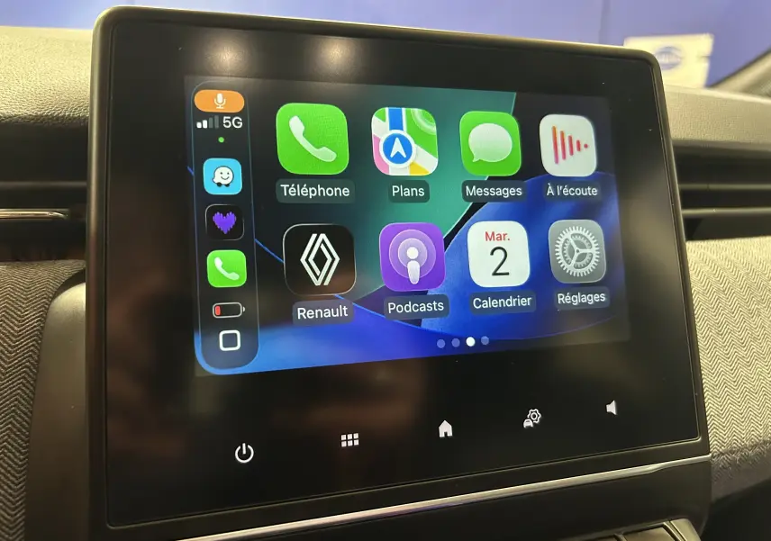 Écran tactile central de la Renault Clio V gris Rafale, affichant l’interface Apple CarPlay avec icônes colorées.