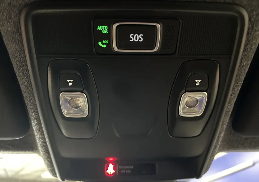 Vue en gros plan du plafonnier intérieur noir avec bouton SOS et lampes de lecture dans une Renault Clio V gris Rafale métal.