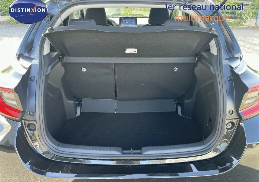 Coffre ouvert d'une Toyota Yaris Hybrid 116ch noir métal vue arrière, montrant l'espace de chargement et l'intérieur du véhicule.